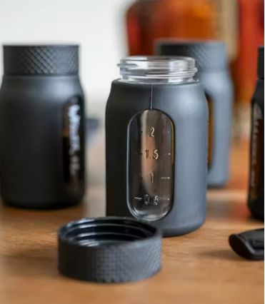Black glass jars with measurement markings.
