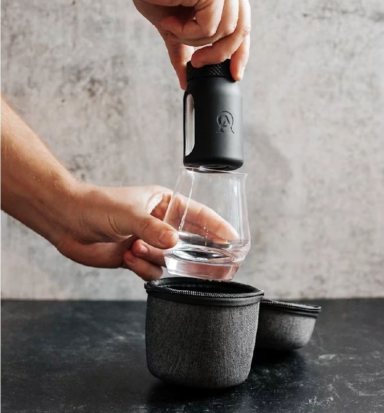 Hand using portable coffee maker on cup.