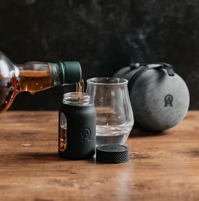 Pouring whiskey into travel-sized bottle.